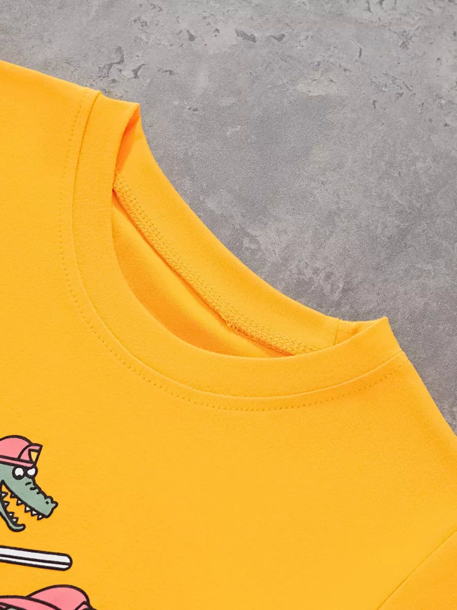 Yellow crew neck t-shirt with cartoon alligator graphic and pink accents.
