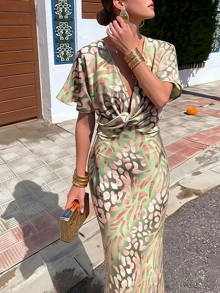 Twist-front animal print maxi dress with deep V-neck and short sleeves in green and pink.