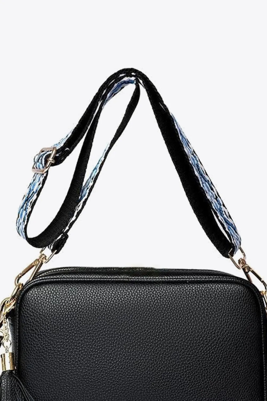 Black pebbled leather crossbody bag with patterned strap and tassel detail