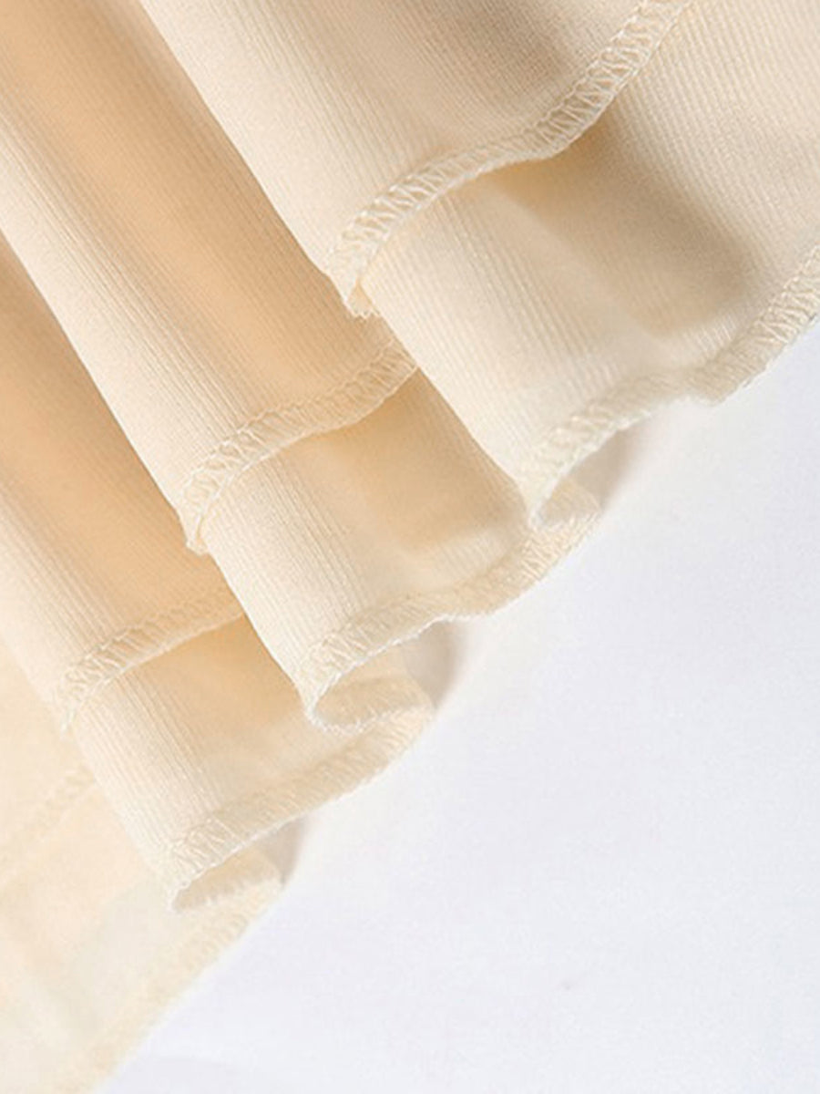 Backless ruffled mini dress detail showing layered fabric and ruffled hem in cream.
