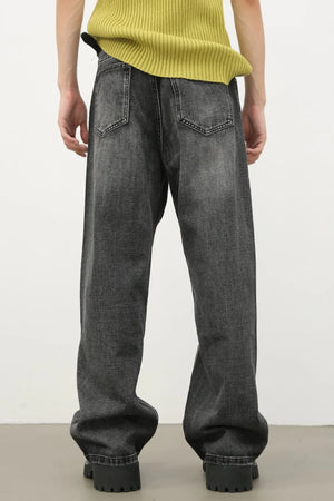 Baggy fit dark washed denim jeans with knee rips and a casual style.
