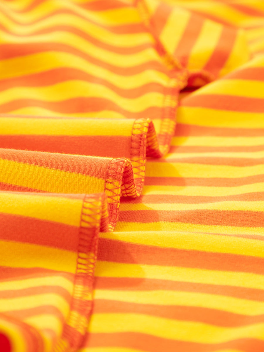 Striped round-neck t-shirt in tangerine and yellow cotton with visible stitching detail.
