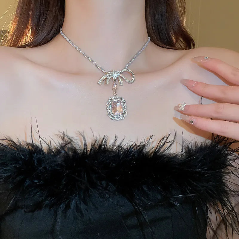 Silver bow pendant necklace with crystal drop, alloy and copper.