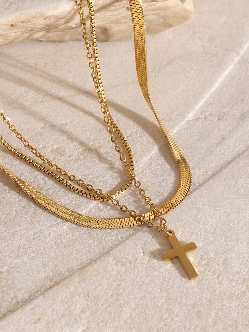 Gold layered necklace with snake chain and cross pendant