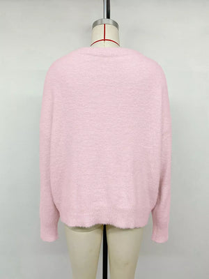 Pink fuzzy crewneck sweater with long sleeves and a scalloped hem.