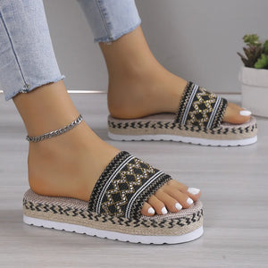 Embroidered platform espadrille slides in black with geometric pattern and rope detail.
