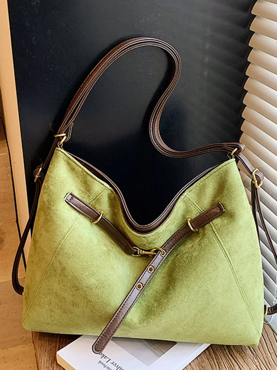Green suede tote bag with brown trim and strap details