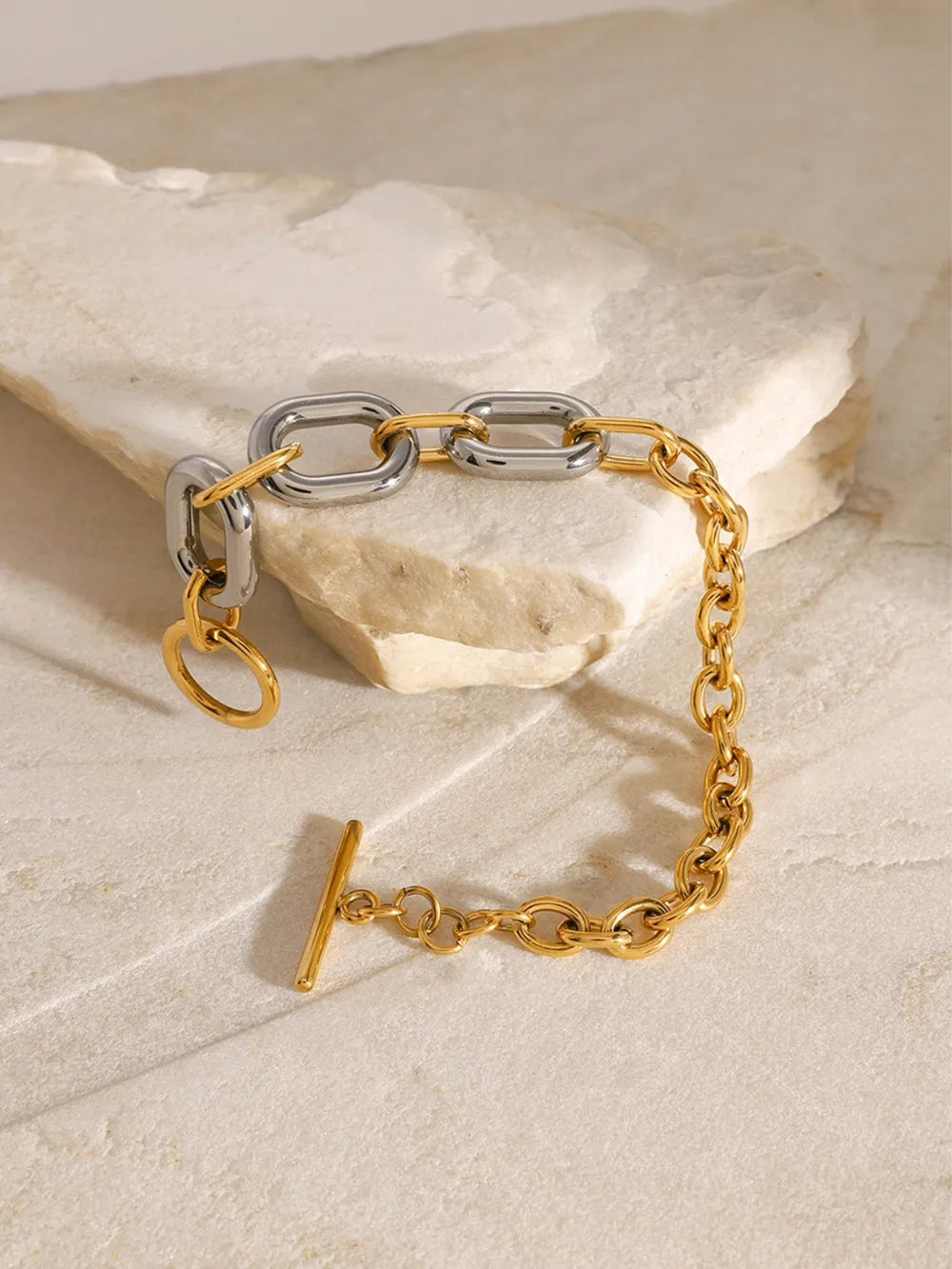 Two-tone chain link bracelet with toggle clasp and gold accent ring.