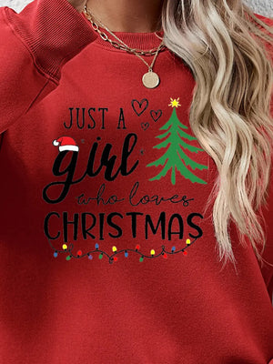 Red crewneck sweatshirt with "Just a girl who loves Christmas" graphic and festive lights.