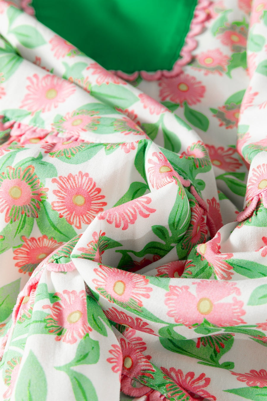 Women's tiered mini dress with pink floral print, green lining, and ruffled trim.