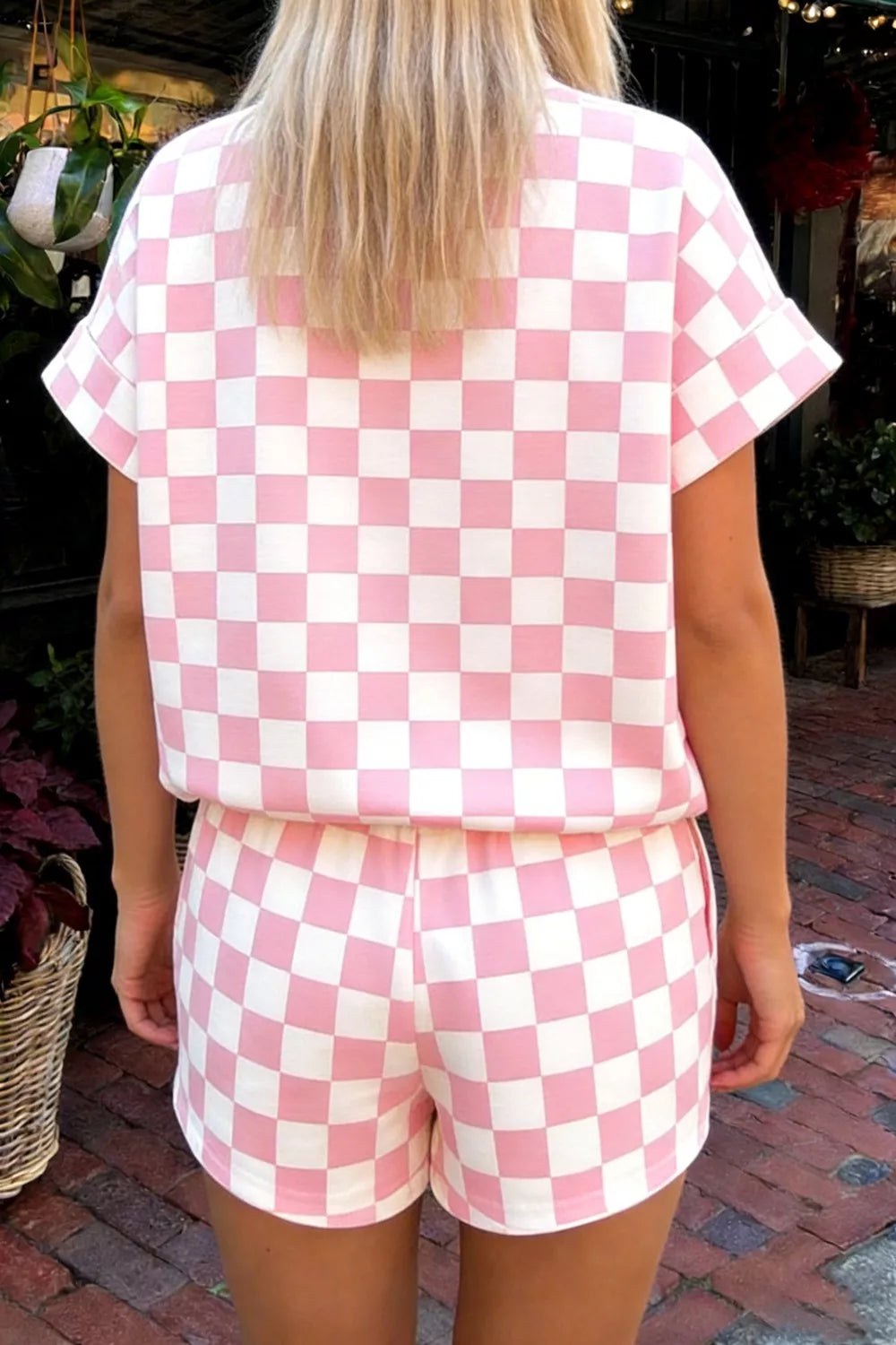 Chic checkerboard blush pink and white two-piece set with shorts and short sleeve top.