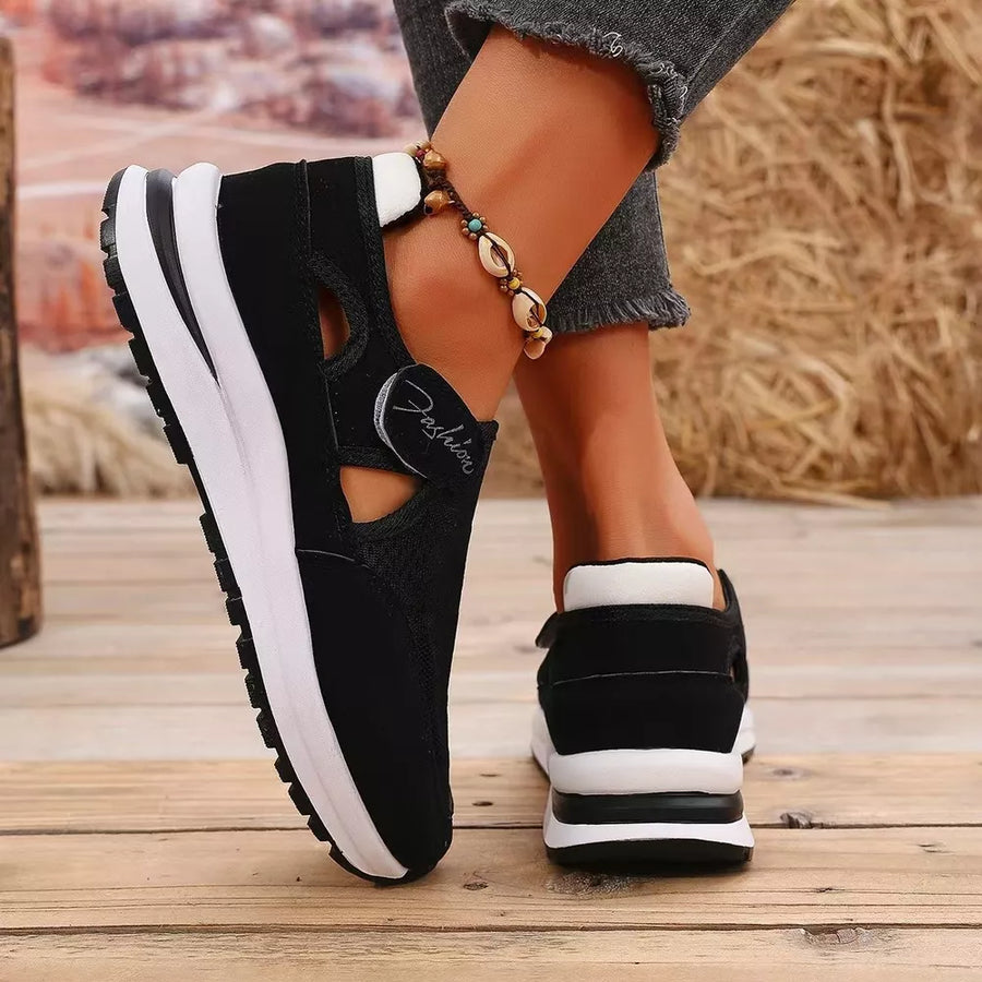 Black cutout slip-on sneakers with white soles and "Fashion" detail.