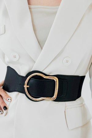 Black elastic waist belt with sculpted gold buckle, cinching a cream blazer.