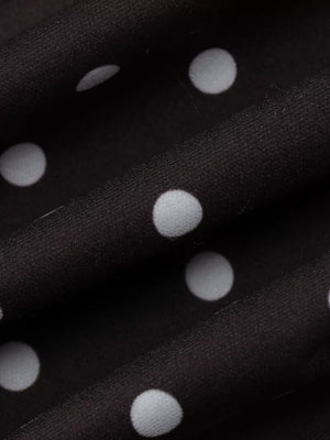 Chic polka dot mini dress in black with white dots, featuring a cut-out detail.