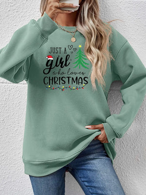 Sage green crewneck sweatshirt with "Just a girl who loves Christmas" graphic and festive lights.