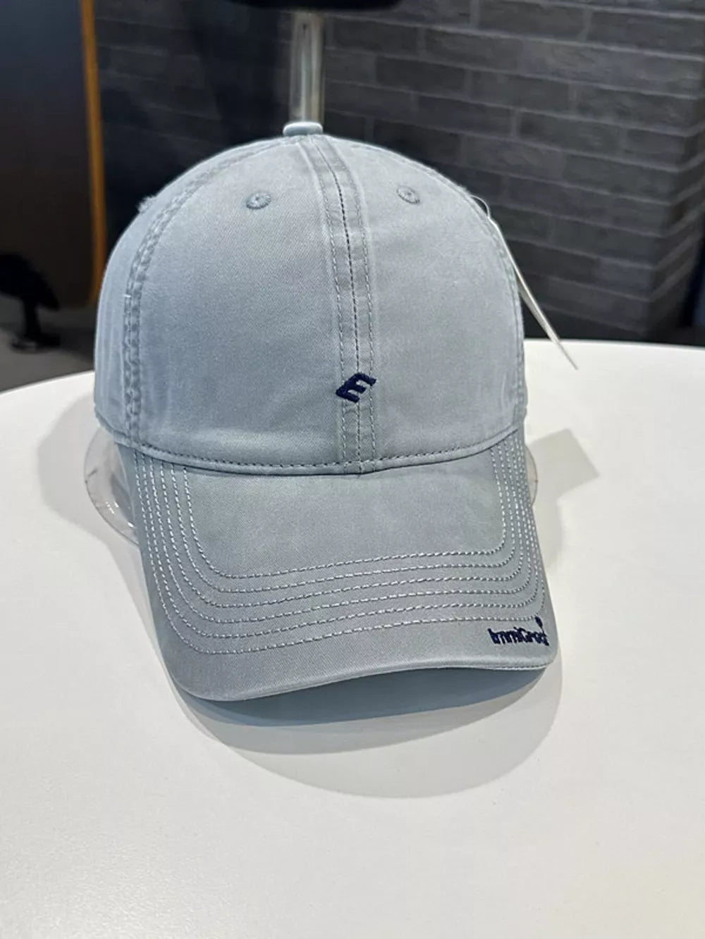 Gray blue cotton baseball cap with curved brim and embroidered logo detail
