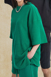 Green waffle knit boxy t-shirt with short sleeves and crew neck, styled casually.