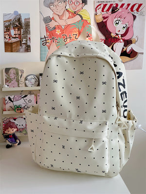 White polka dot bowknot backpack with front pocket and side pockets.