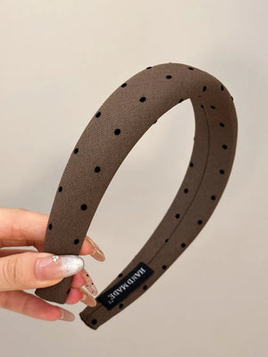 Brown padded headband with black polka dots and a handmade label