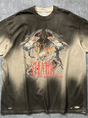 Distressed khaki t-shirt with a bold shark graphic and distressed details.