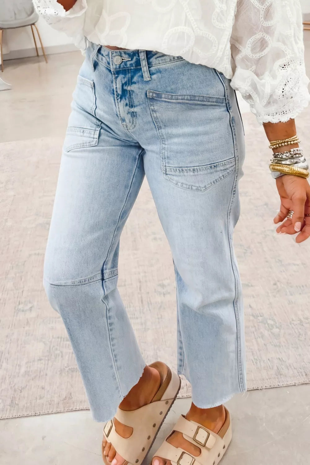 Light wash denim jeans with utility pockets and raw hem