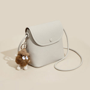 Mini pebbled pu leather crossbody bag in white with a fluffy charm