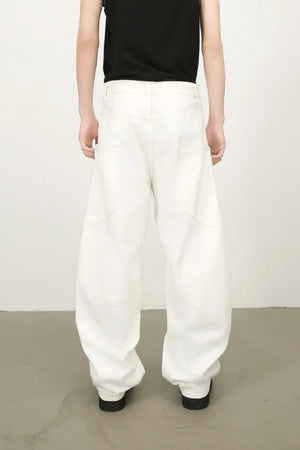 White wide leg trousers with sculpted pocket details and a relaxed fit.