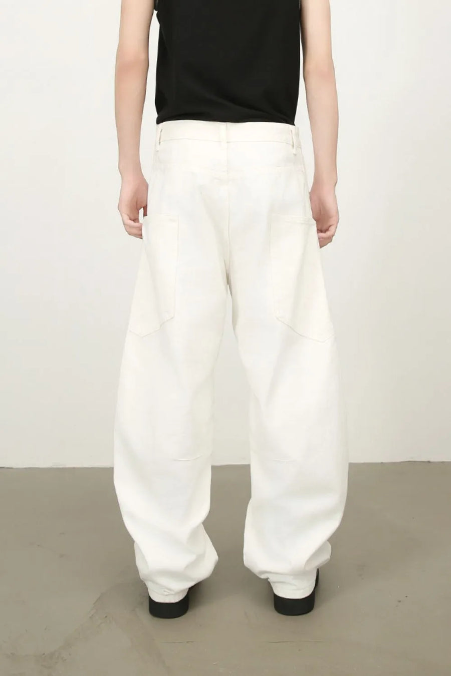 White wide leg trousers with sculpted pocket details and a relaxed fit.