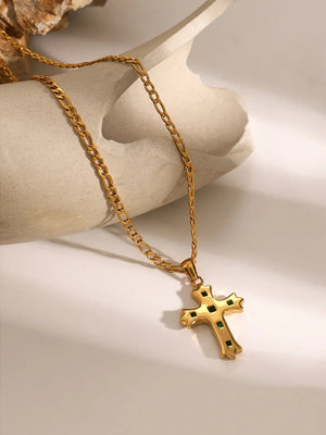 Gold cross pendant necklace with green zirconia accents on a figaro chain.