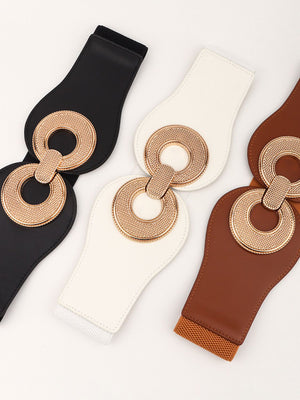 Black, white, and caramel elastic belts with sculpted metalwork circular buckle detail