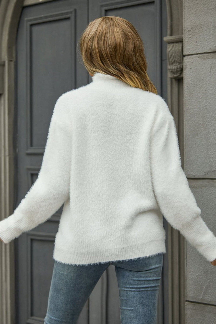 White fluffy mock neck sweater with long sleeves and ribbed cuffs.