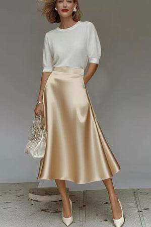 Lustrous midi skirt in champagne satin with hidden pockets and A-line cut.