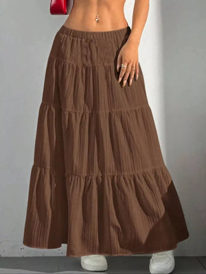 Brown tiered maxi skirt with elastic waistband and textured fabric.