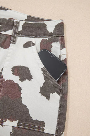 Cow print utility jeans with a phone in the pocket.