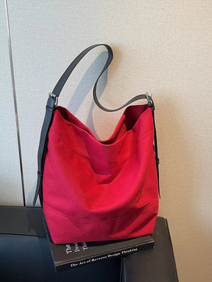 Red hobo bag with adjustable black strap and subtle stitching detail.