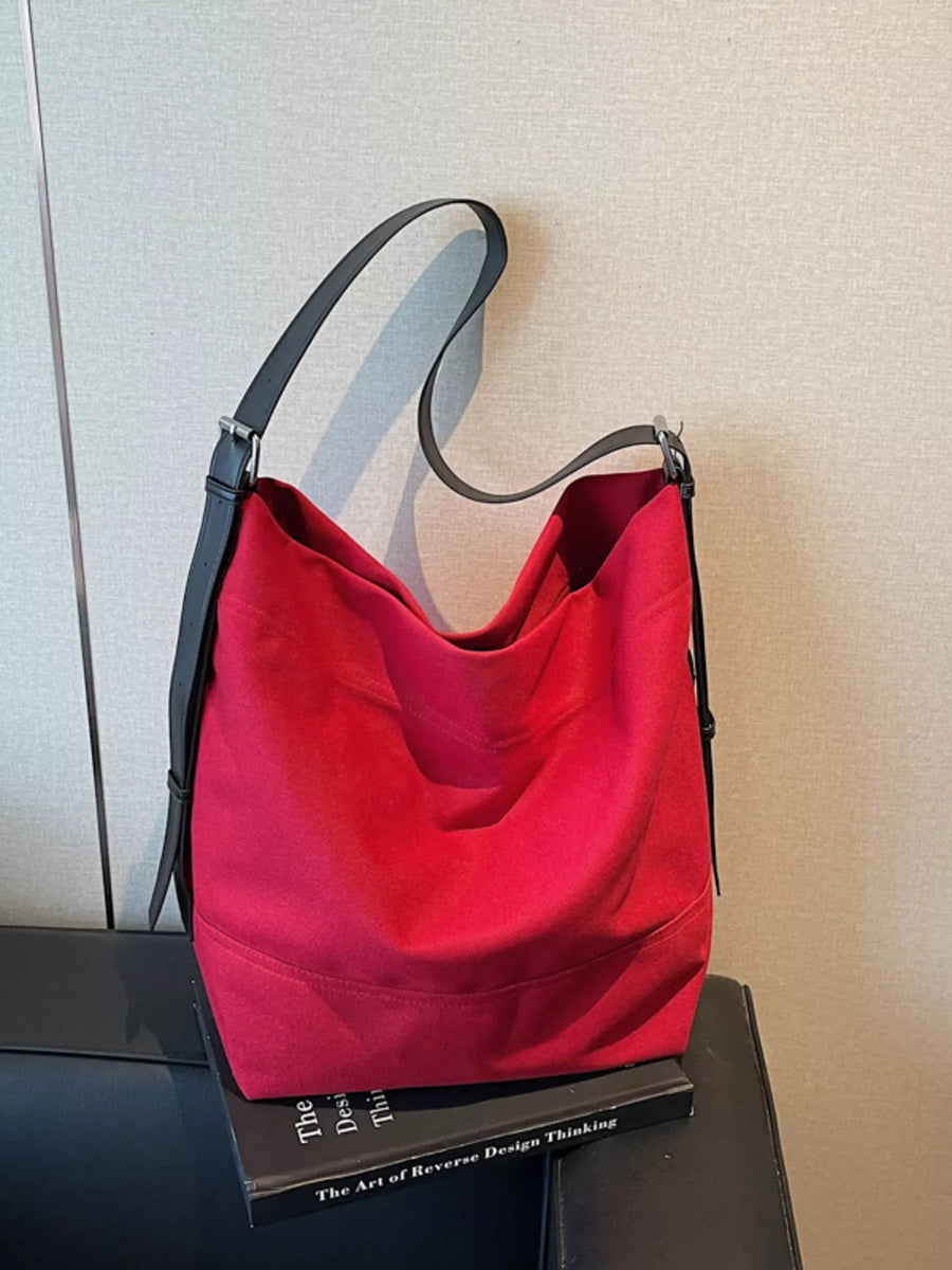 Red hobo bag with adjustable black strap and subtle stitching detail.