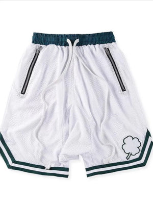 White mesh basketball shorts with dark green trim, drawstring, and zipper pockets.