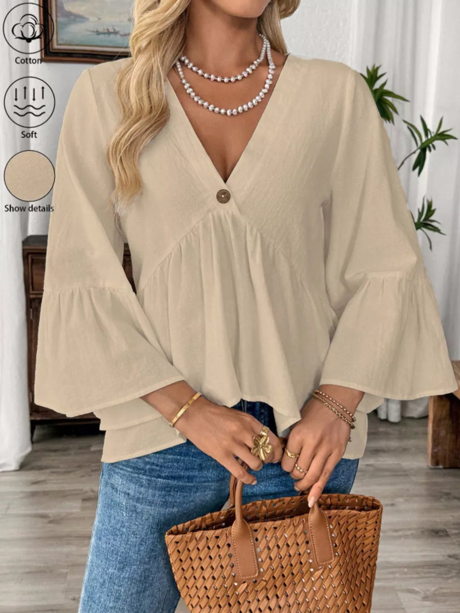 Apricot cotton V-neck blouse with bell sleeves and a single button detail.