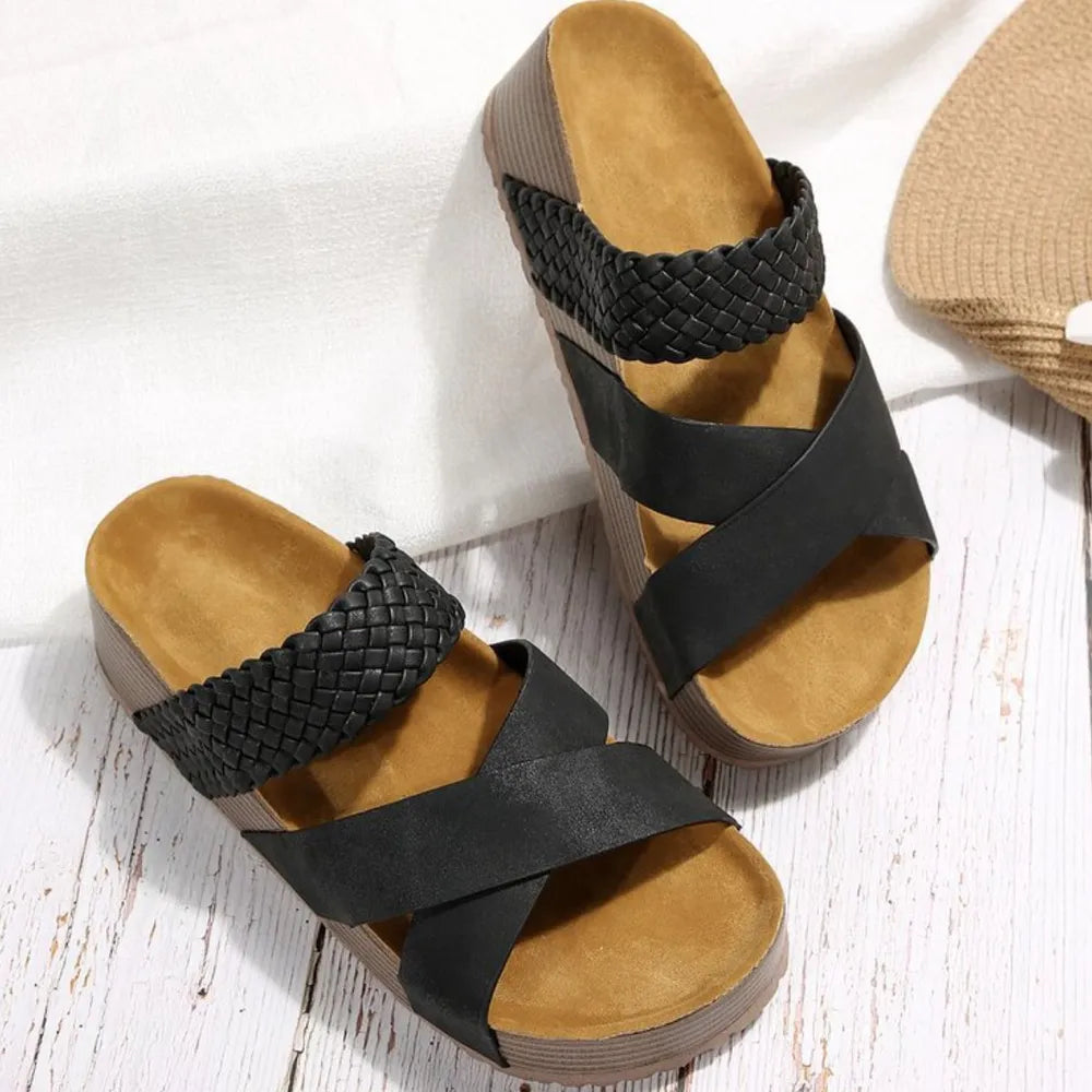 Black braided strap platform slides with crisscross straps and cork sole.