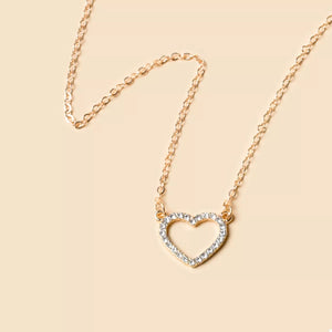 Gold necklace with a dainty, open heart pendant encrusted with clear stones.