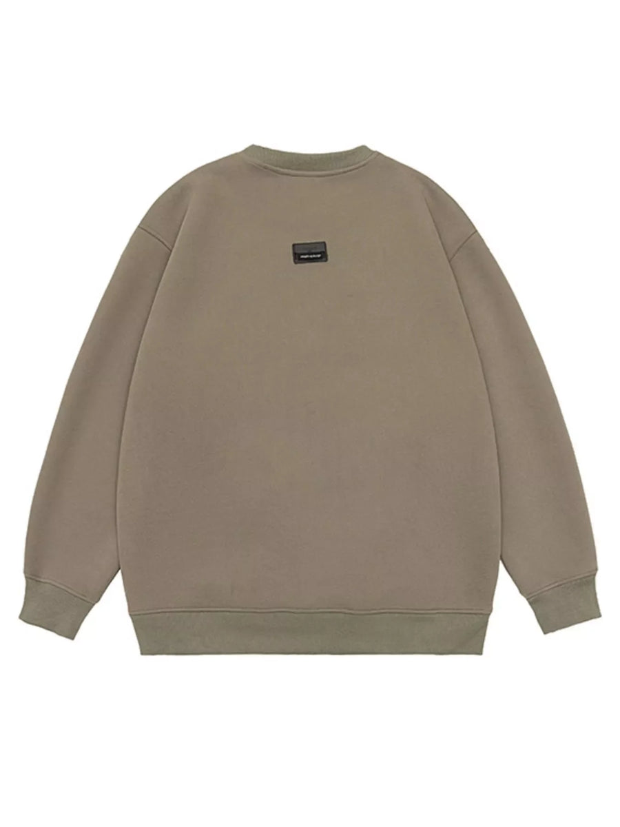 Oversized khaki cotton crew-neck sweatshirt with a small black logo patch on the back.