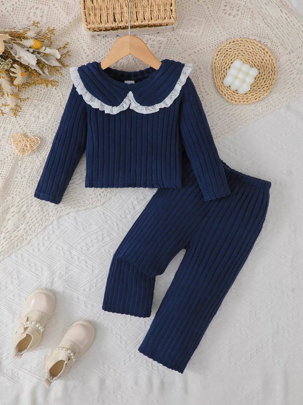 Navy ribbed knit toddler girls' ensemble with lace collar and matching pants.