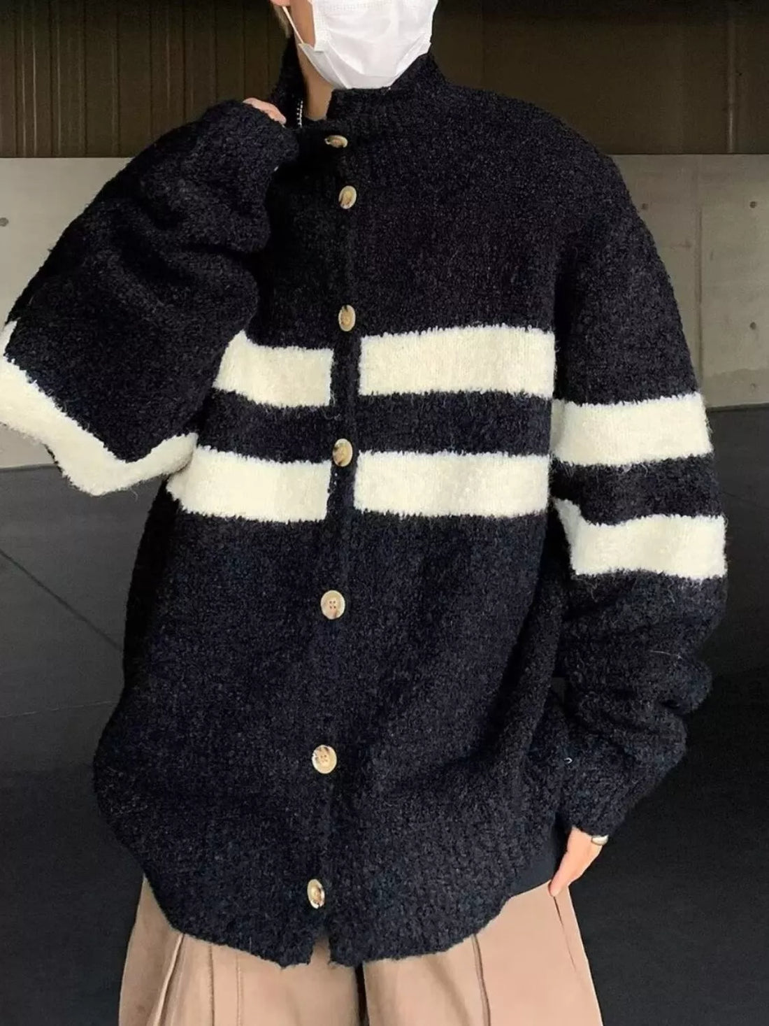 Black and white striped knit cardigan with button-down front and mock neck.