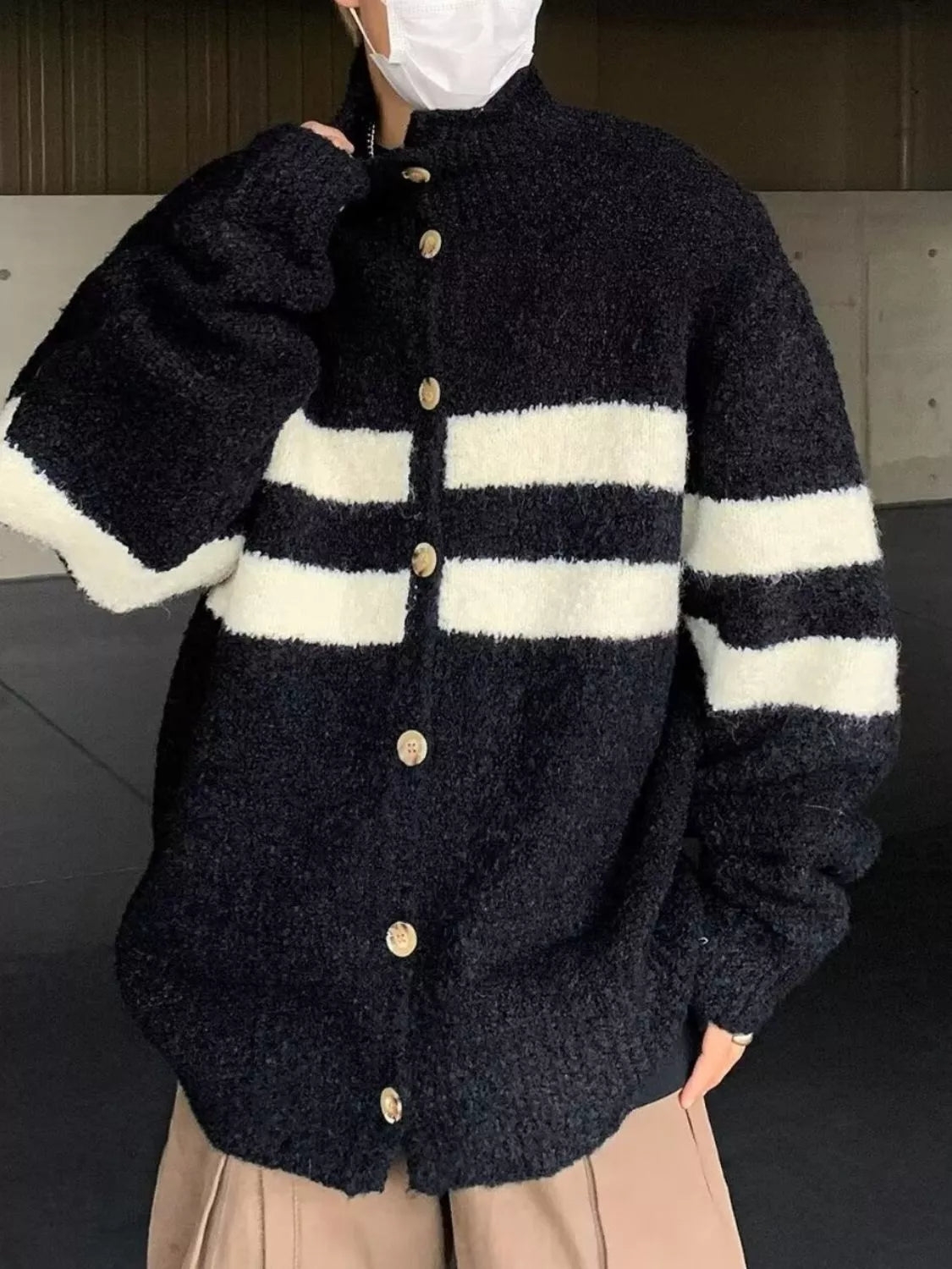 Black and white striped knit cardigan with button-down front and mock neck.
