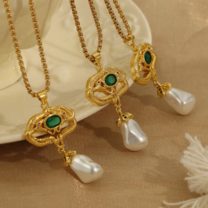 Gold botanical pearl drop pendant necklace with green gemstone and snake detail.