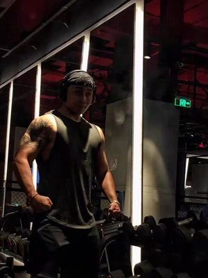 Black athletic tank top with V-neck and kanji graphic detail, worn by a man in a gym.