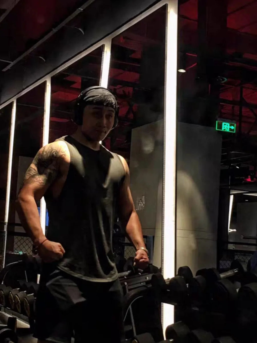 Black athletic tank top with V-neck and kanji graphic detail, worn by a man in a gym.