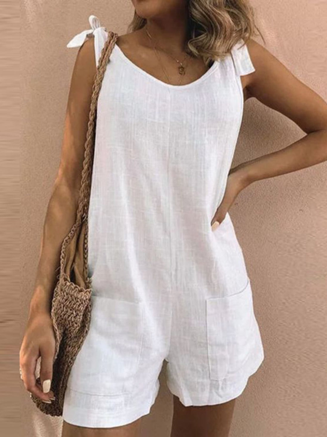 romper in off-white featuring adjustable straps and relaxed fit