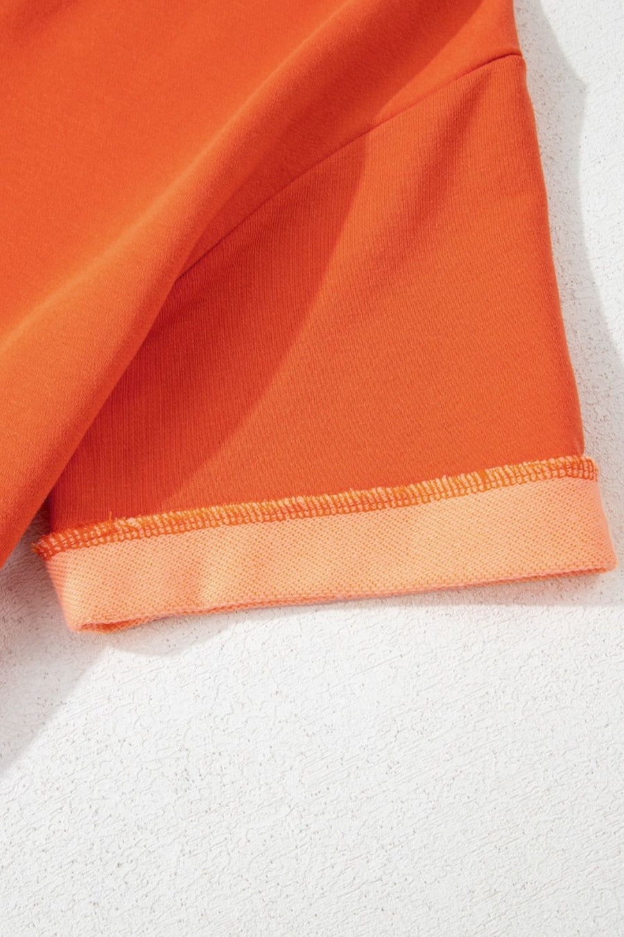 Orange colorblock V-neck romper with cuffed hem detail