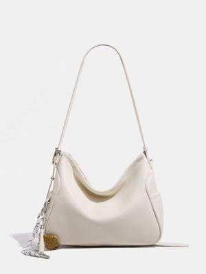 handbag in cream featuring adjustable strap and relaxed fit